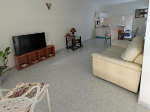 a living room with a couch and a flat screen tv at Ponta Gato Residence in Tarrafal