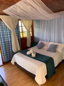 a bedroom with a bed with two stuffed animals on it at TARAHARA salud y bienestar in Santandercito