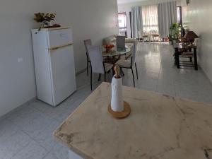 a kitchen with a table and a white refrigerator at Ponta Gato Residence in Tarrafal +6 photos
