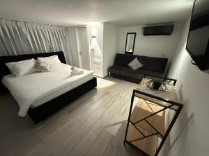 a bedroom with a large bed and a couch at אחוזת רוממה - Villa Romema in Safed +28 photos