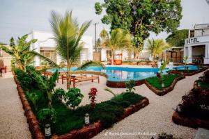 a resort with a swimming pool and palm trees at Googles Beach Hotel Zanzibar in Zanzibar City