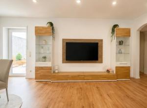 a living room with a flat screen tv on a wall at Ferienwohnung Bayer in Gründau