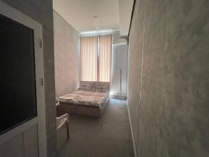 a bedroom with a bed in a room with a window at Shodlik Hotel 