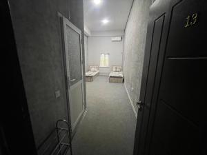 an empty hallway with a room with a chair and a door at Shodlik Hotel 