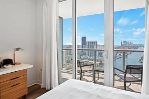 a bedroom with a bed and a balcony with a view at Upper Studio Stunning Intracoastal Views in Hallandale Beach
