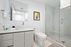 a white bathroom with a toilet and a shower at Upper Studio Stunning Intracoastal Views in Hallandale Beach