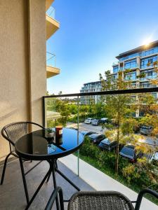 a balcony with a table and chairs and a view of a parking lot at Cozy family apartment at Seabreeze Nardaran, Beach & Pool, Polo Residence in Baku