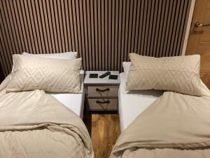 two beds sitting next to each other in a room at The Anfield Apartment in Liverpool