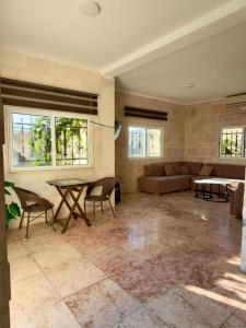 a living room with a table and a couch at Entire Home Near Deadsea & Baptism Site Pool, Garden, BBQ, Great Price in Shūnat Nimrīn