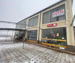 a hotel building with snow on the ground at Shodlik Hotel 
