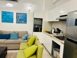 a living room with a couch and a kitchen at Apartment Leeza in Uswetakeiyawa
