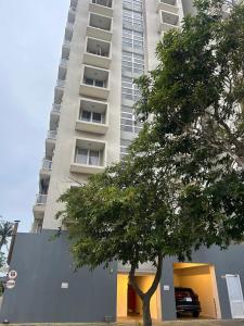 a tall building with a tree in front of it at Apartment Leeza in Uswetakeiyawa