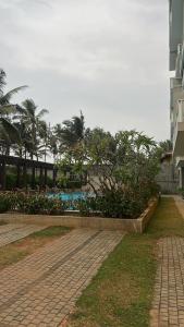 a resort with a pool and palm trees and a building at Apartment Leeza in Uswetakeiyawa