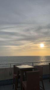 a table and chairs on a balcony with the ocean at Apartment Leeza in Uswetakeiyawa