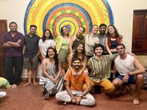 a group of people posing in front of a mural at Happy Panda Hostel Arambol Goa in Arambol