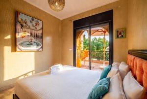 a bedroom with a bed and a view of a patio at Atlas Golf Resort in Marrakesh +42 photos