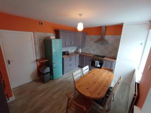 a kitchen with a wooden table and a green refrigerator at Mutton House in Milltown Malbay