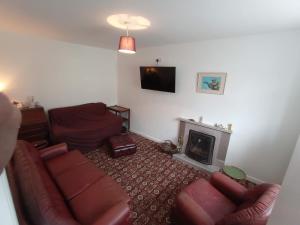 a living room with a couch and a fireplace at Mutton House in Milltown Malbay