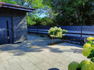 a small tree in a yard next to a fence at Graphite Residence Chynowo in Chynowo