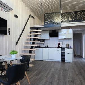 a kitchen with a staircase and a table and chairs at DOMKI POD DĘBAMI , Radawa in Radawa