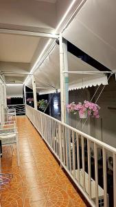 a balcony with pink flowers and a table and chairs at Sindy's Hostel in Pattaya