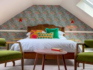 a bedroom with a bed and two chairs at The White Rabbit Rooms in Broadford