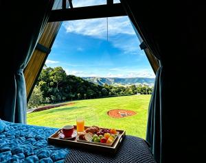 a tray of fruit on a table in a room with a window at Refugio Pertinho do Céu in São Pedro