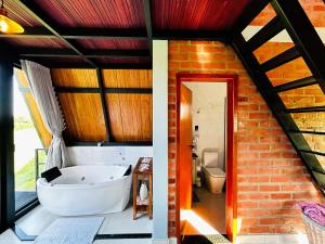 a bathroom with a white tub and a brick wall at Refugio Pertinho do Céu in São Pedro +69 photos