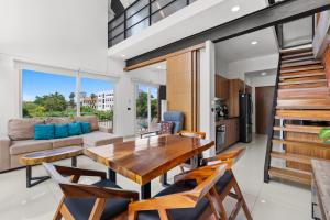a kitchen and living room with a wooden table and chairs at Monyxbnb at Zoho Skies in Puerto Vallarta