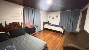 a bedroom with two beds in a room with wooden floors at Casa Vista Cafe in Cartago