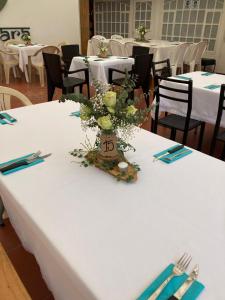 a table with a white table cloth with a vase of flowers at TARAHARA salud y bienestar in Santandercito +39 photos