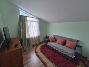 a living room with a couch and a window at Ananuri Veranda-Guest House in Ananuri