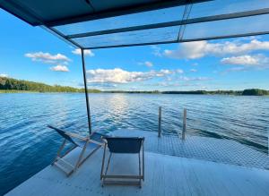 a chair sitting on a boat on the water at Houseboat Dąbrowica in Dąbrowica