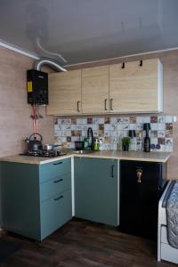 a kitchen with white and blue cabinets in a room at Houseboat Dąbrowica in Dąbrowica