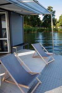 a couple of chairs sitting on the back of a boat at Houseboat Dąbrowica in Dąbrowica +3 photos