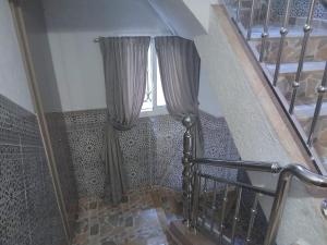 a staircase with curtains and a window in a building at S&R Appartements in M'diq