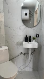 a white bathroom with a toilet and a sink at House Tickon Ostrog in Trubasinj +6 photos