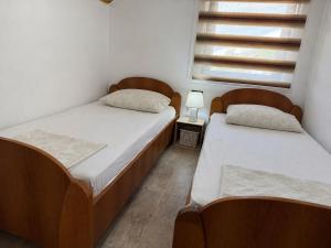 two twin beds in a room with a window at House Tickon Ostrog in Trubasinj