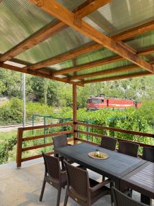 a table and chairs on a deck with a train at House Tickon Ostrog in Trubasinj