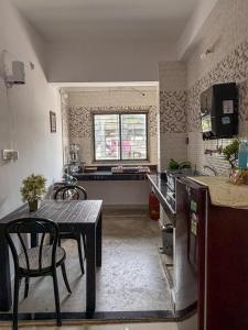 a kitchen with a table and a table and chairs at Eden Stay in Siliguri