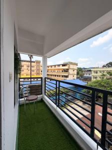 a balcony with a chair and a view of the city at Eden Stay in Siliguri
