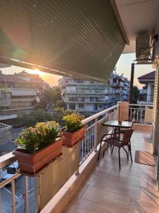 a balcony with three potted plants and a table at Nikoletta in Katerini