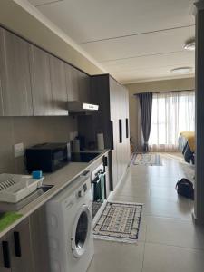 a kitchen with a washing machine in a room at Studio Luxe The Aura Your Calm Escape in Northriding