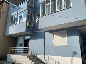 a blue building with stairs in front of it at Te gjoli in Pogradec