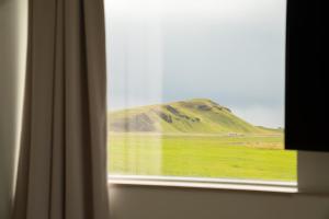a view of a mountain from a window at Farmhouse in Vík