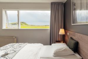 a bedroom with a bed and a large window at Farmhouse in Vík