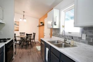 a kitchen with a sink and a table with chairs at Pet-Family-Friendly Duplex with Parking in Wasilla +12 photos