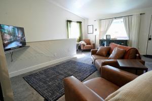 a living room with couches and a flat screen tv at Pet-Family-Friendly Duplex with Parking in Wasilla