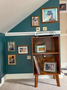 a room with a blue wall with pictures at The White Rabbit Rooms in Broadford