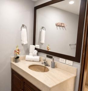 a bathroom with a sink and a large mirror at Apartamentos - Torre de Cali in Cali